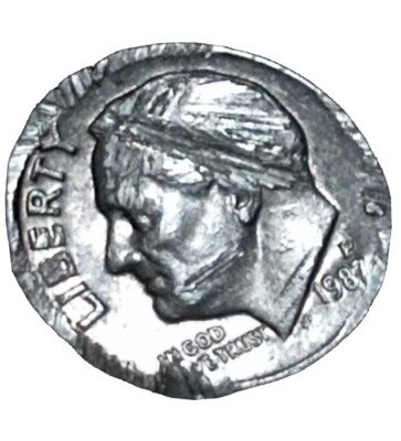 1987 Roosevelt dime struck-through error showing incuse impression where foreign object was trapped during striking